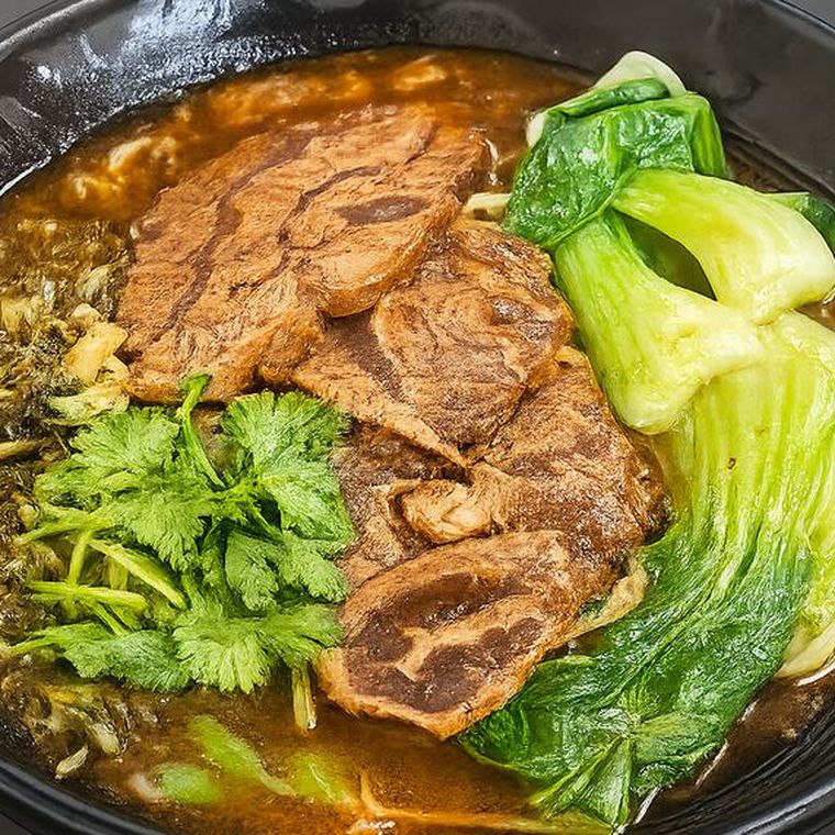 Braised beef noodle soup with bok choy, pickled greens and cilantro