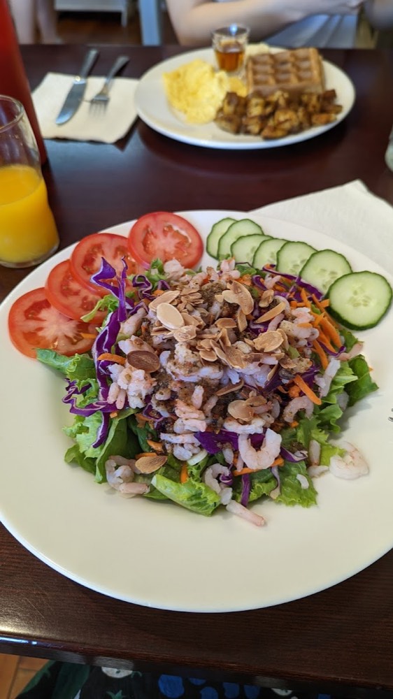 Shrimp salad with toasted almonds, red cabbage, carrot, cucumber and sliced tomato